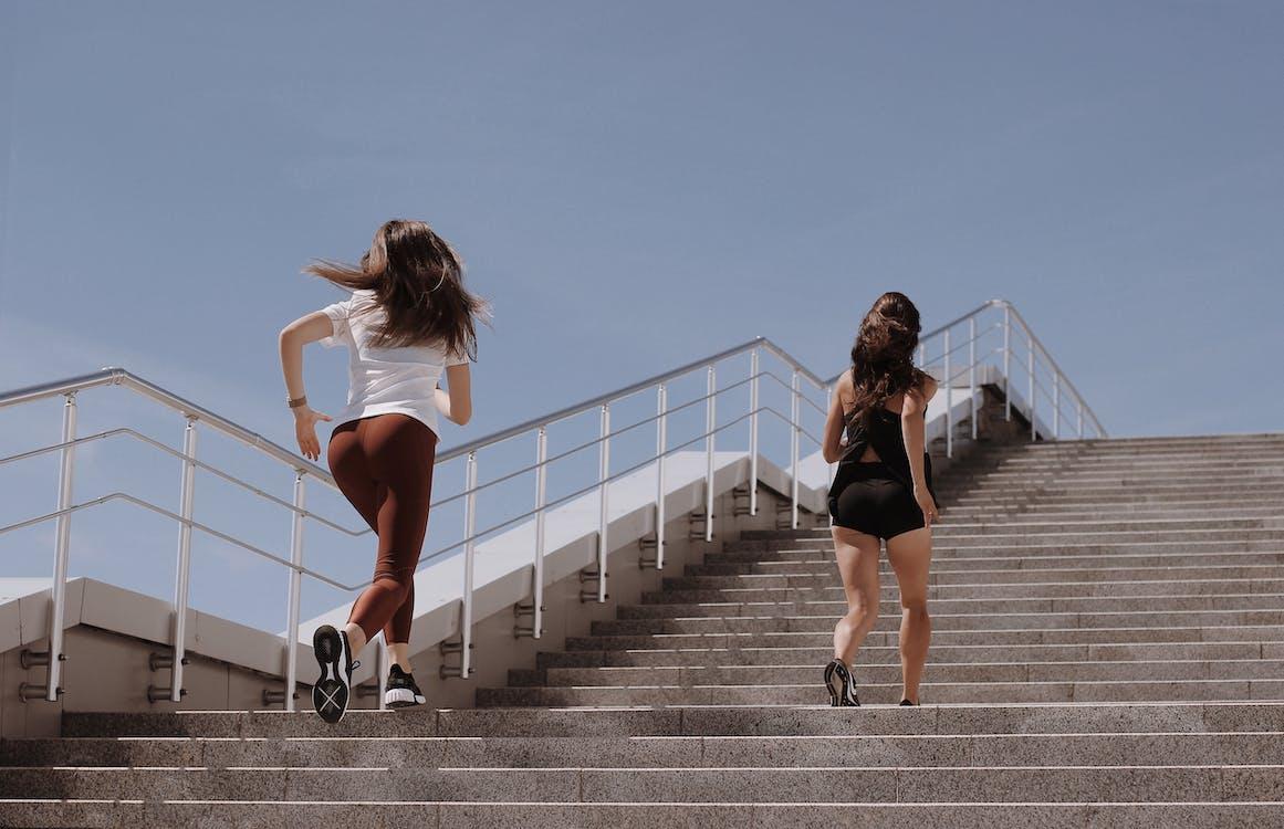 Free 2 Women Walking on Gray Concrete Bridge Stock Photo