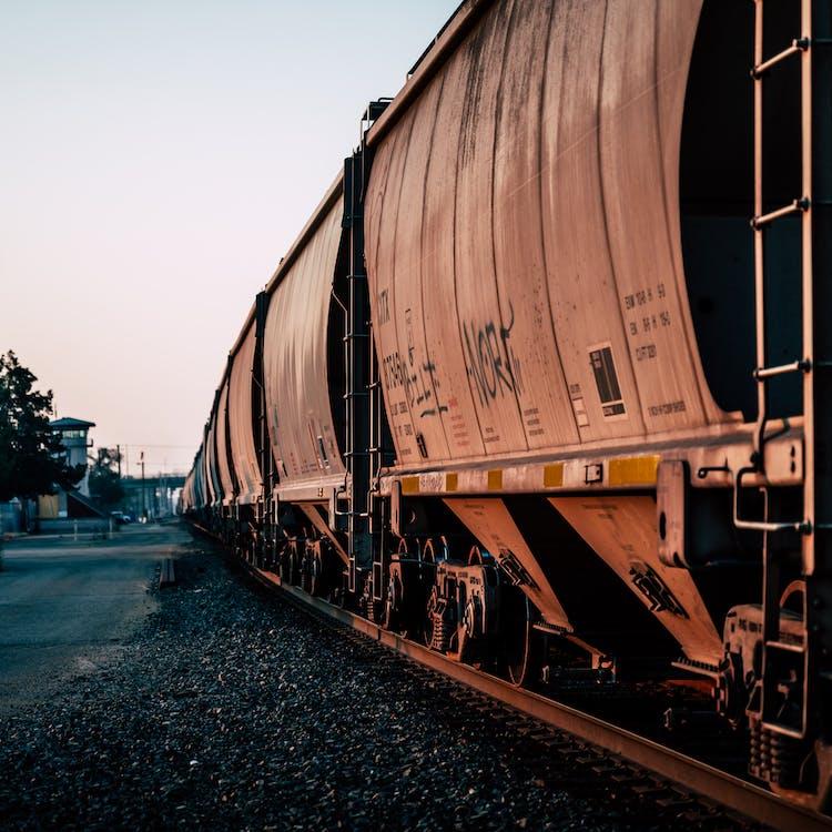 Free Large metal rusty train for carrying goods on railroad at station at daytime Stock Photo