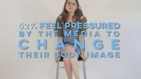 A gif of a woman sat on a chat straightening her glasses (on loop). The caption over-laid on the gif reads: "52% feel pressured by the media to change their body image"