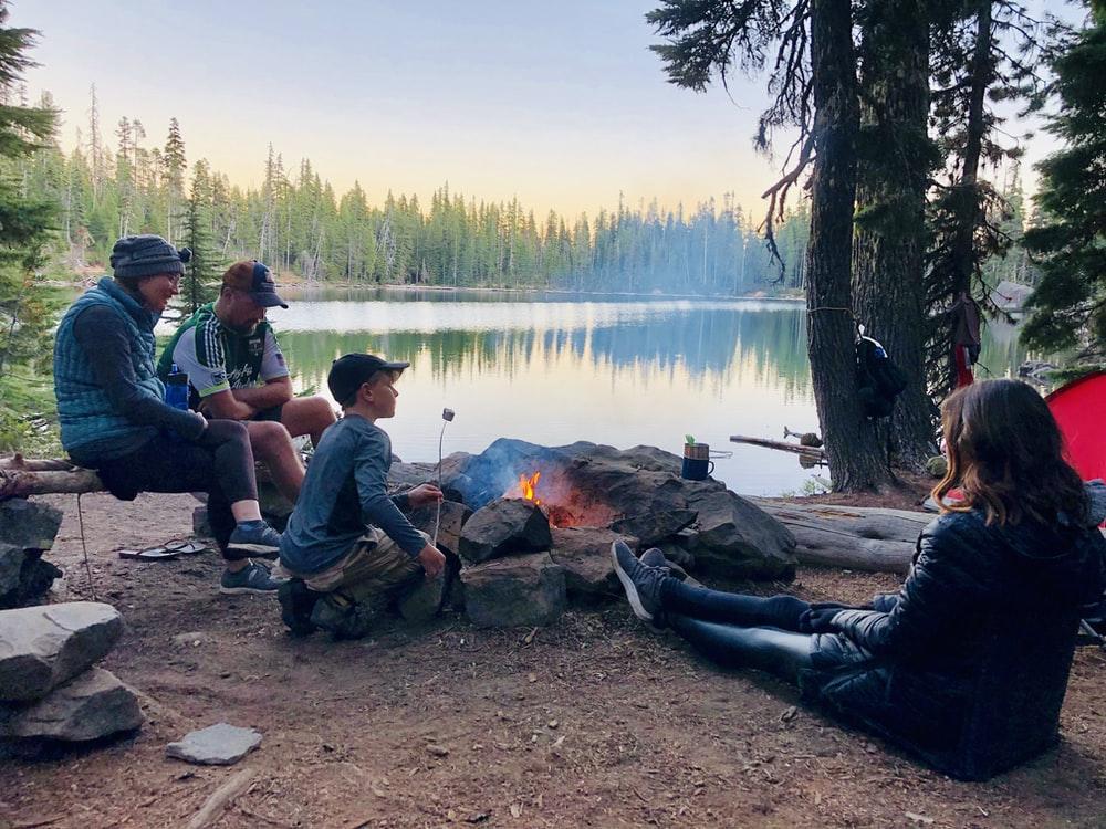 people camping in front of lake