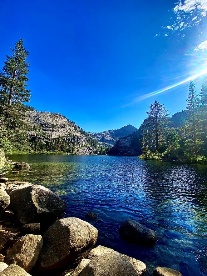 A body of water with trees and rocks

Description automatically generated