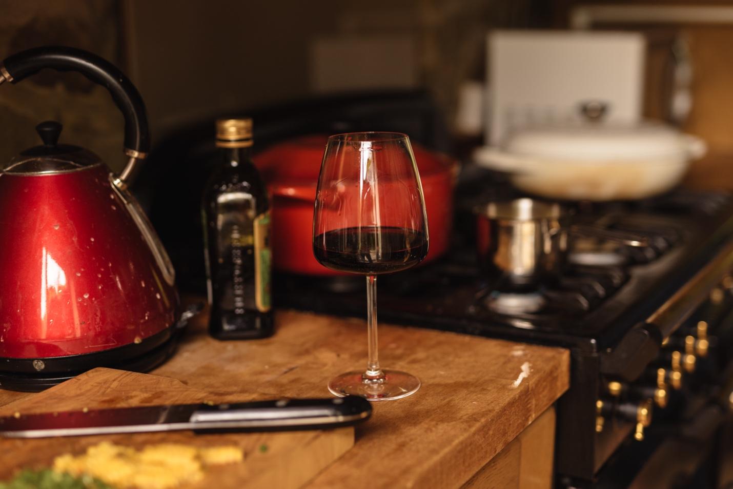 A glass of wine on a counter

Description automatically generated