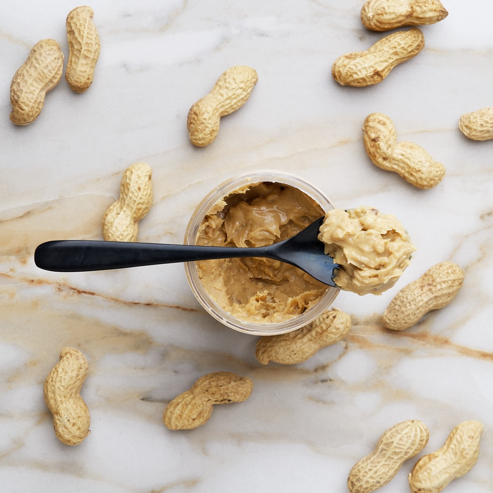 Jar of peanut butter with spoon. 