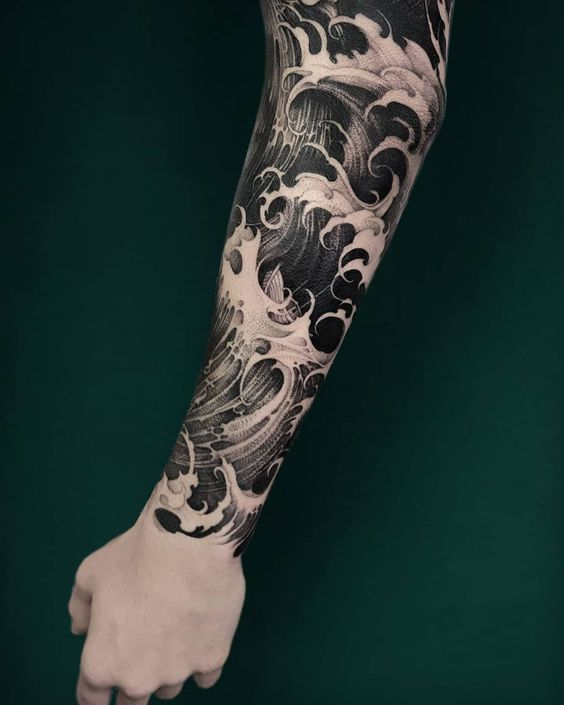 Full picture of a guy showing off sleeve wave tattoo