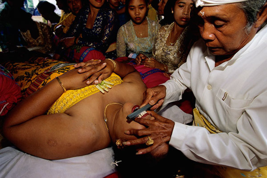 A Brahmin priest files a woman's teeth. © Anders Ryman/Corbis