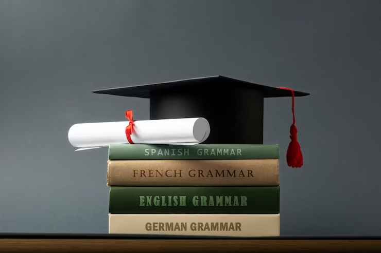 A mortarboard, diploma, and grammar books representing academic achievement and learning.