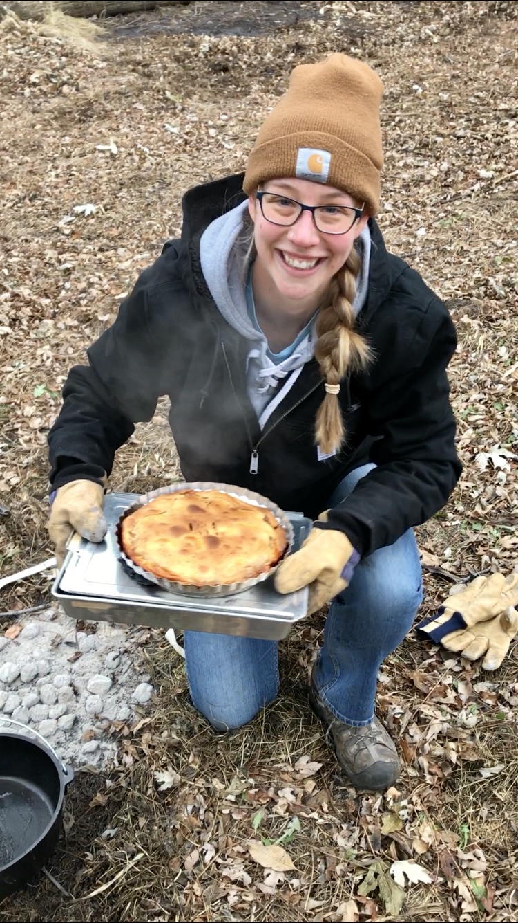 Annie holding her pie made in a Dutch oven.