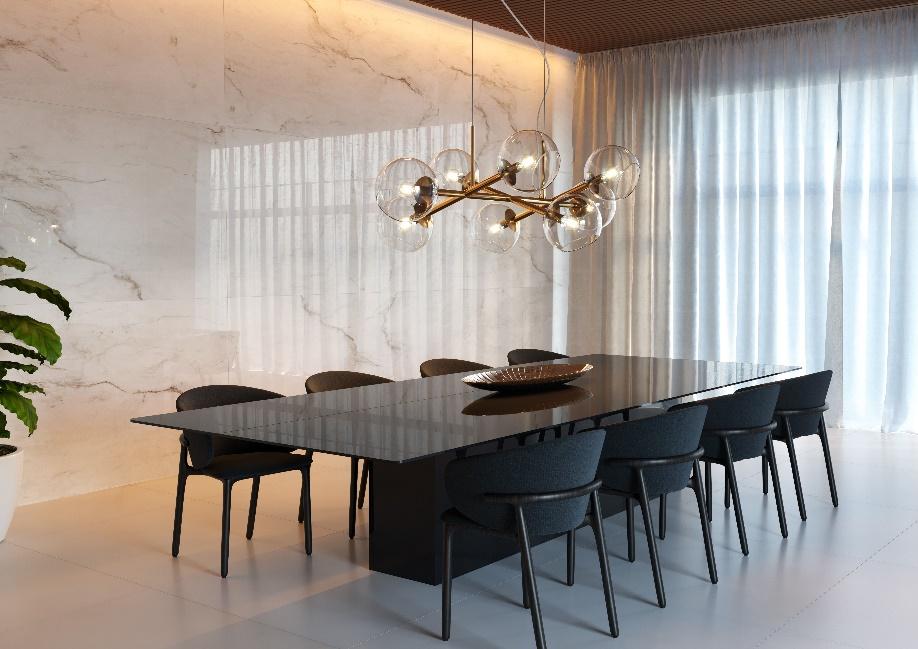 Sala de jantar com mesa preta com 9 cadeiras pretas, piso porcelanato branco, luminária pendente de bolas transparentes, parede com revestimento marmorizado branco e janela com cortina longa.