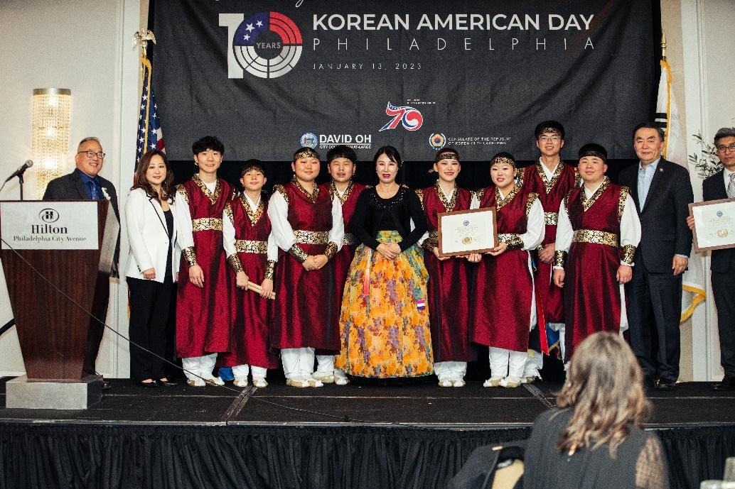 A group of people in red and black robes standing on a stage

Description automatically generated with low confidence