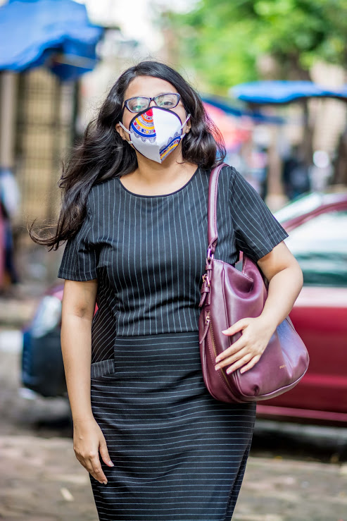 A woman in the blue stripped dress wearing a facemask