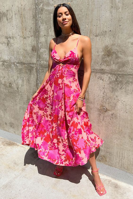 a woman wearing a pink floral dress with pink heels