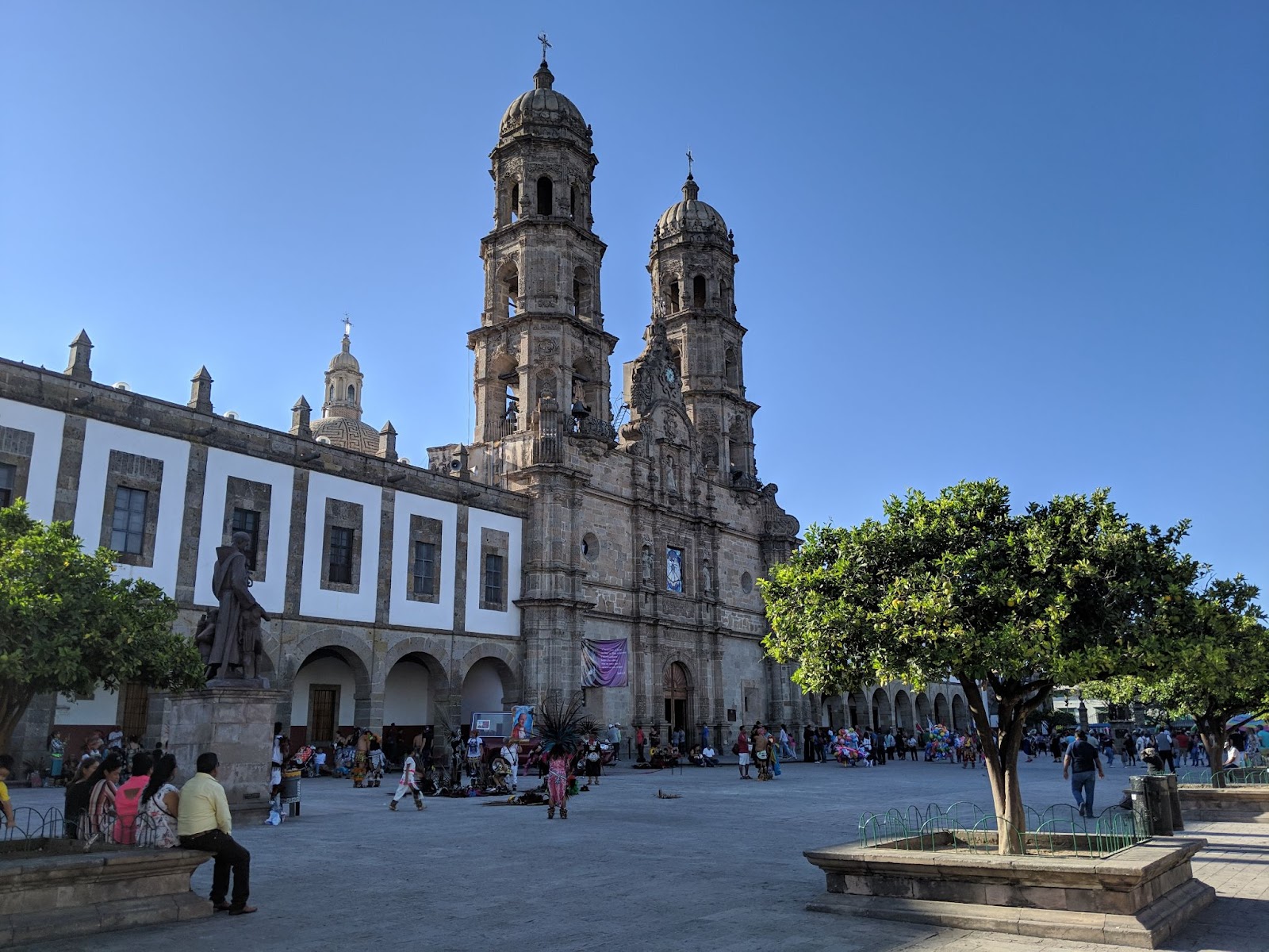 people walking around a plaza in front of a historic basilica 