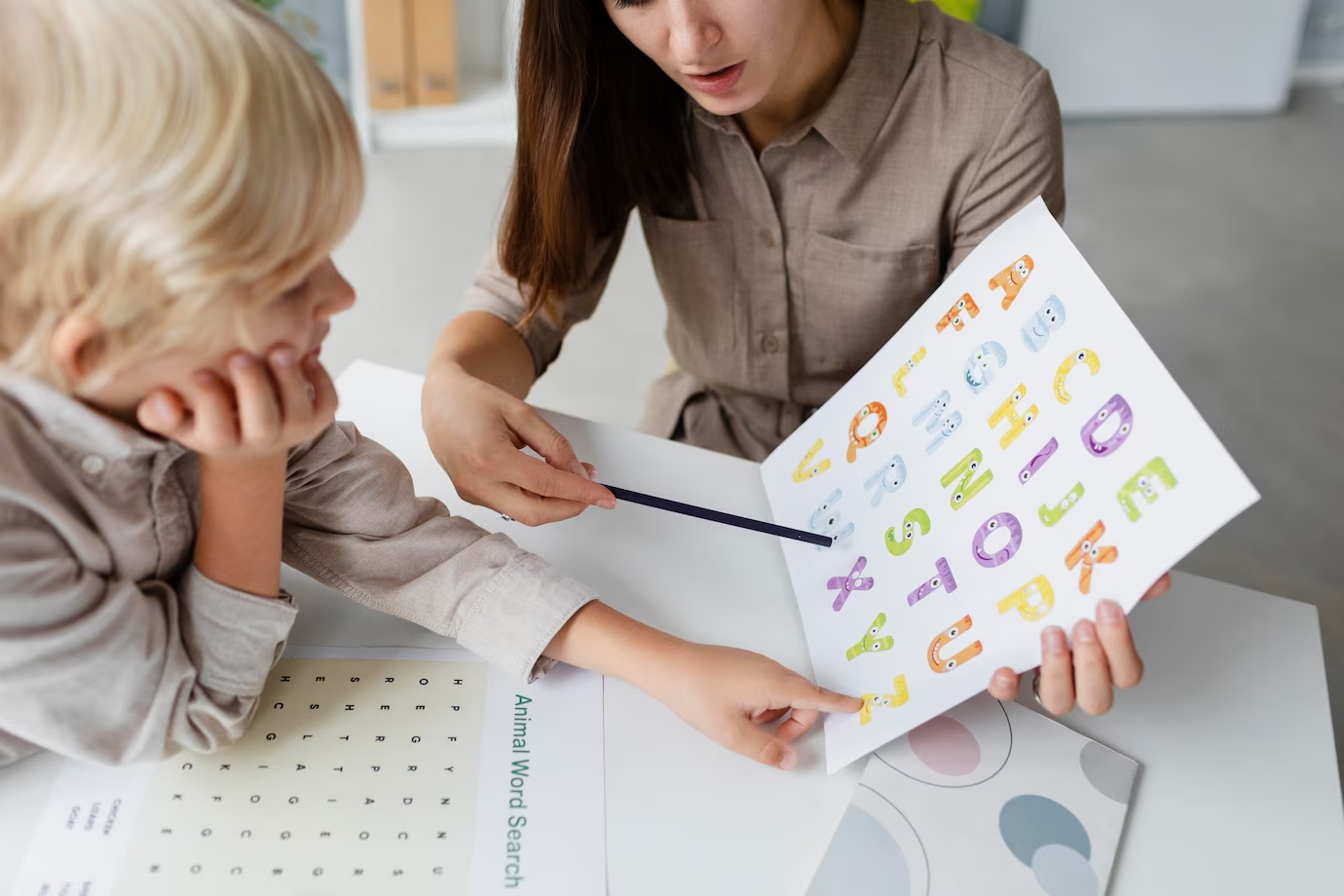 a kid learning phonics with her teacher
