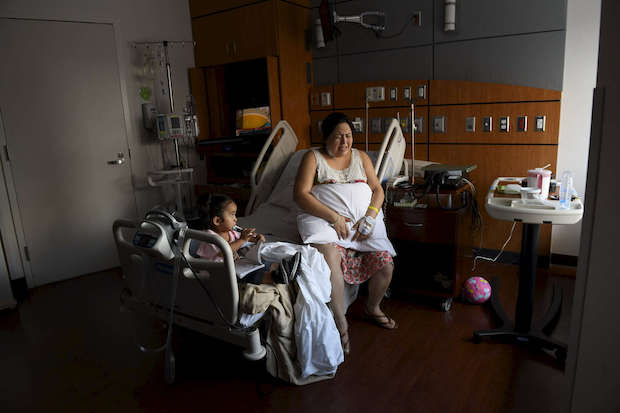 Pregnant woman undergoes contractions in hospital room