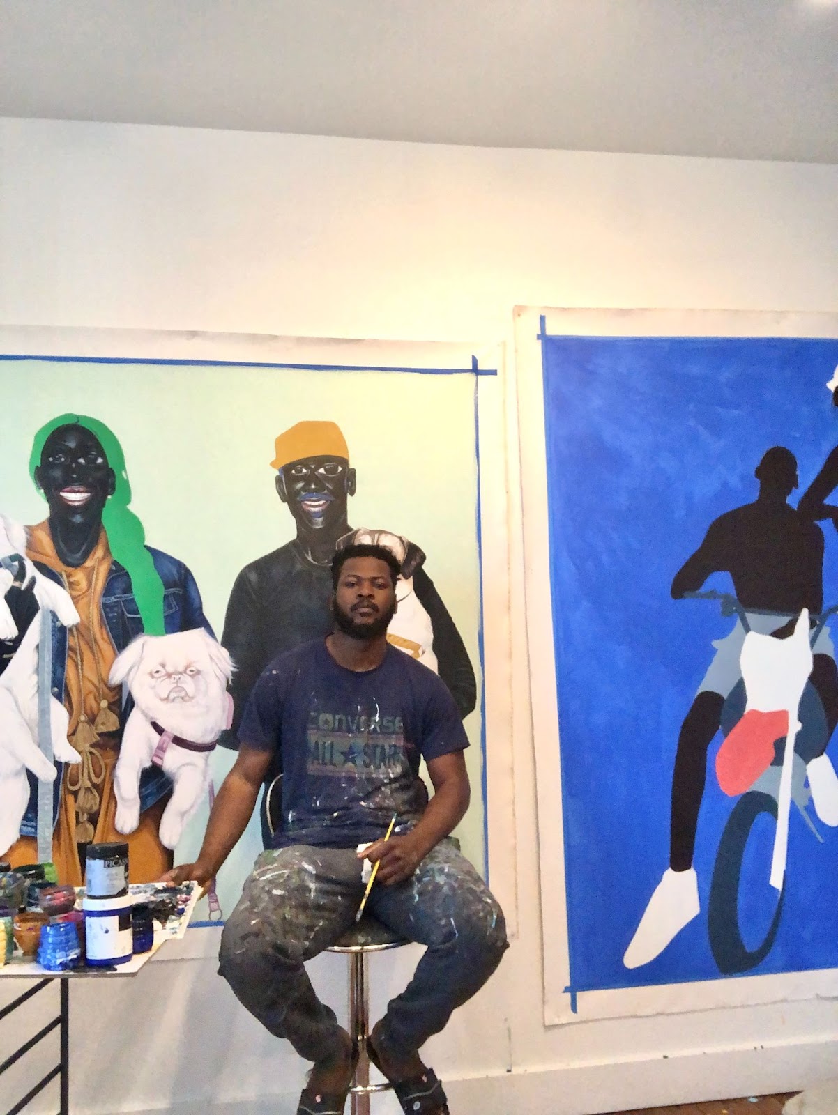 Sesse Elangwe in front of two works in progress