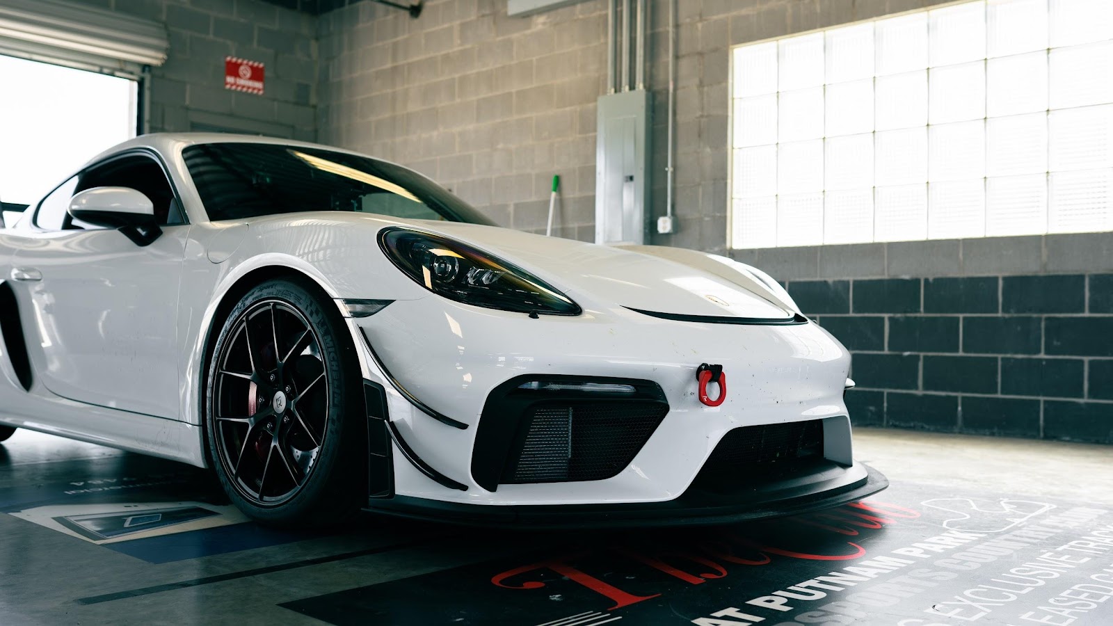 White Porsche 718 GT4 with aftermarket front splitter and dive planes