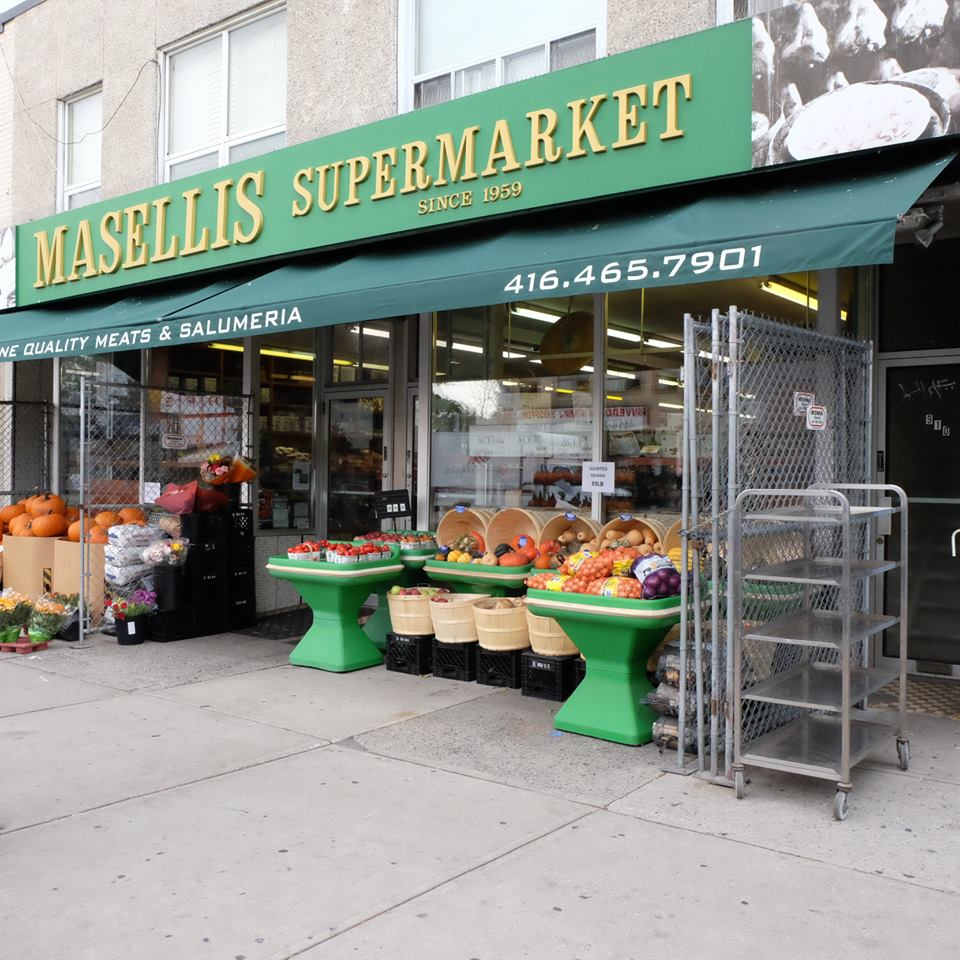 The exterior of a supermarket, It has a green sign with the name "Masellis Supermarket."