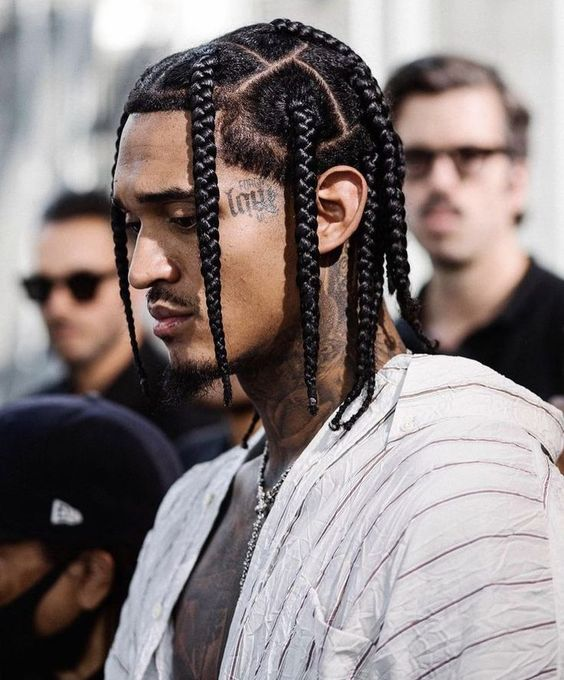 a tattoed guy rocking box braids hairstyles for men 