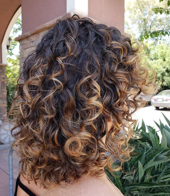 a lady showing her curly highlighting for short hair