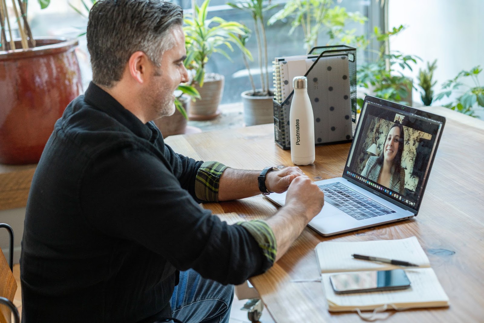 A picture of a man conducting an interview with a woman via video conference.