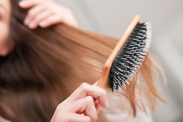 brushing hair with a wooden paddle brush