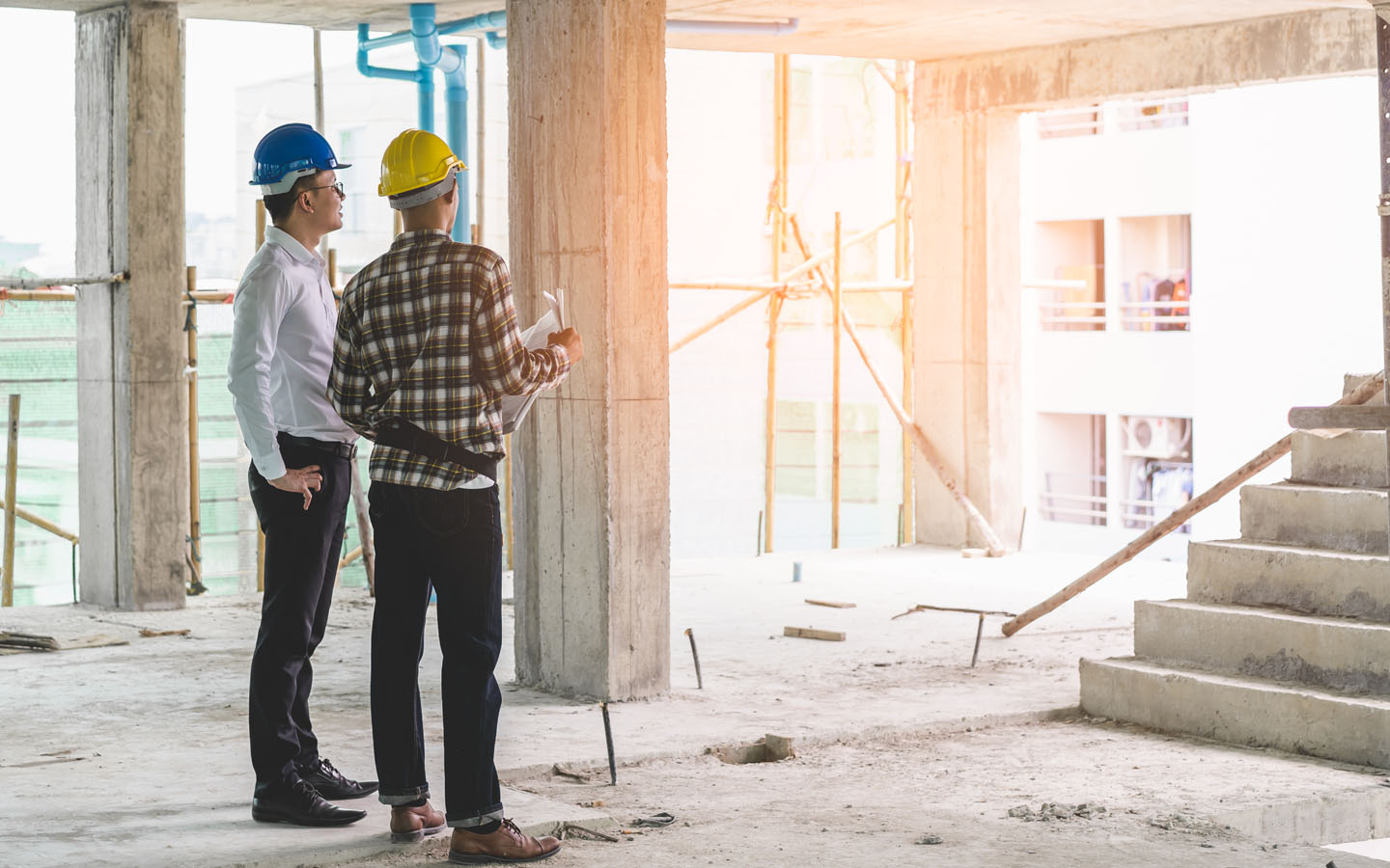construction workers standing and discussing something in an under construction building