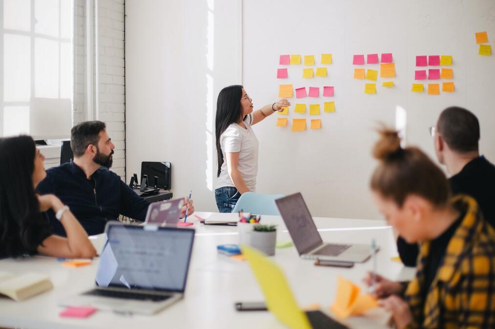 Foto: O Marketing Ops tem como foco a realização de pesquisas para análise do perfil. Pessoas discutindo com quadro branco usando kanban