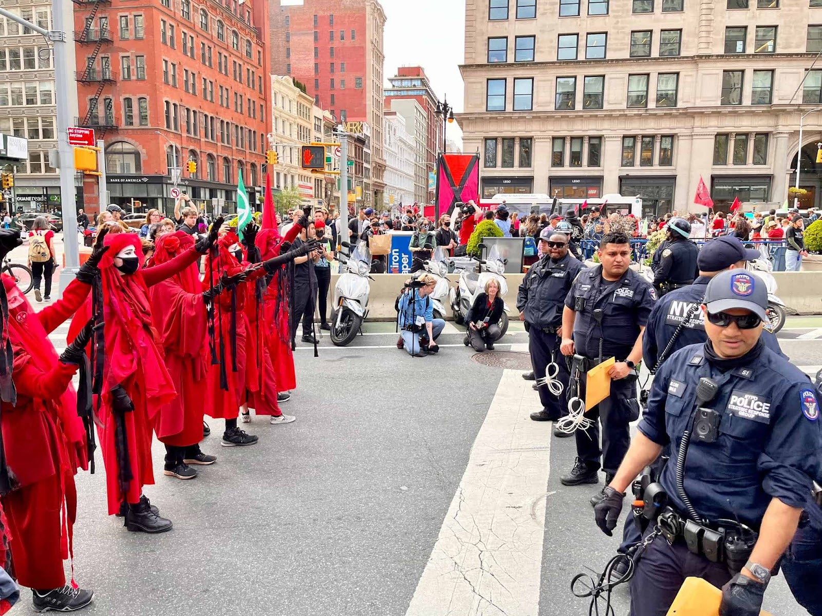 The red brigade stand before a line of police as they block a road in downtown New York