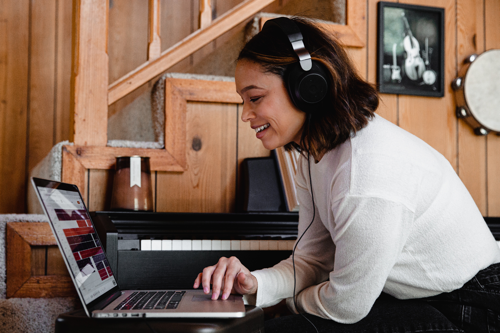 Smiling woman using a laptop with a headset.
