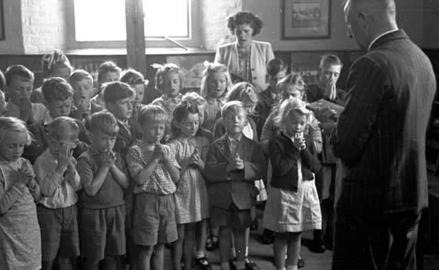 Crianças rezando em escola