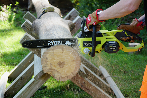 The best battery chainsaw: an image of a Ryobi chainsaw cutting through a log