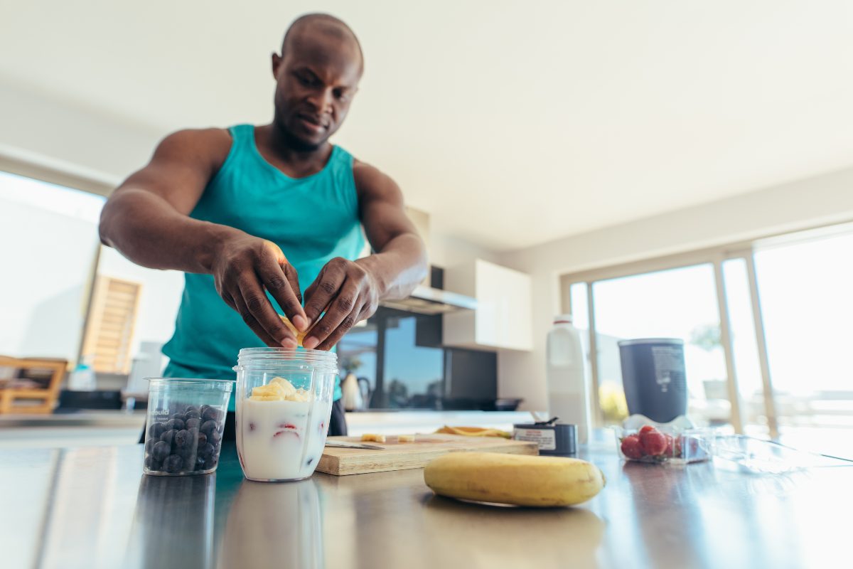 Man making a banana protein smoothie to enhance athletic performance