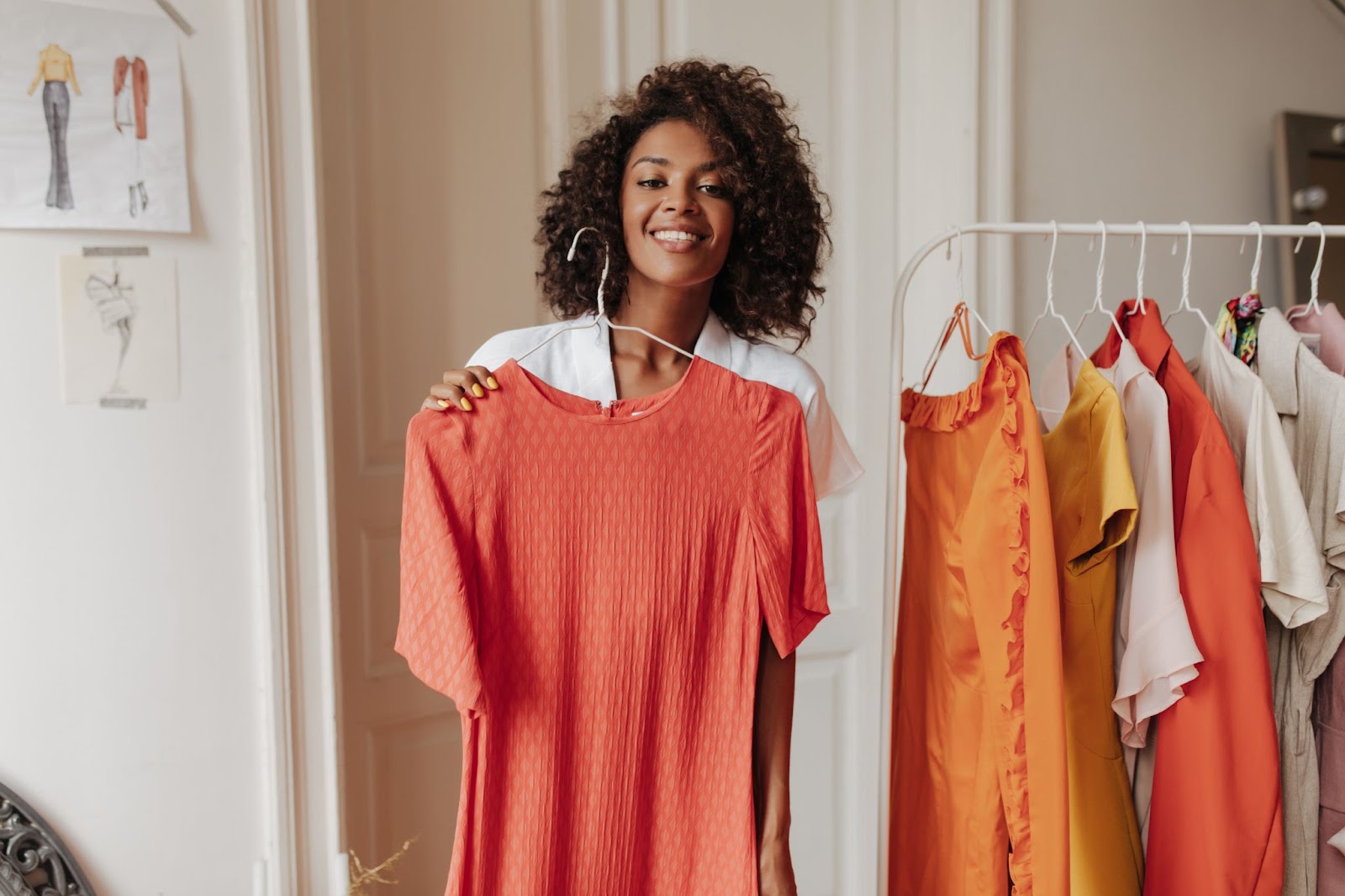 mulher ao lado de uma arara de roupas com peças dentro de sua coloração pessoal