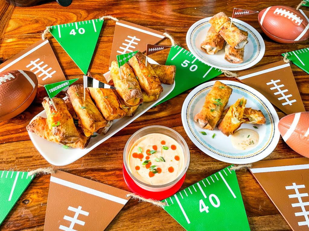 Buffalo Chicken Egg Rolls set out on a table with football decorations