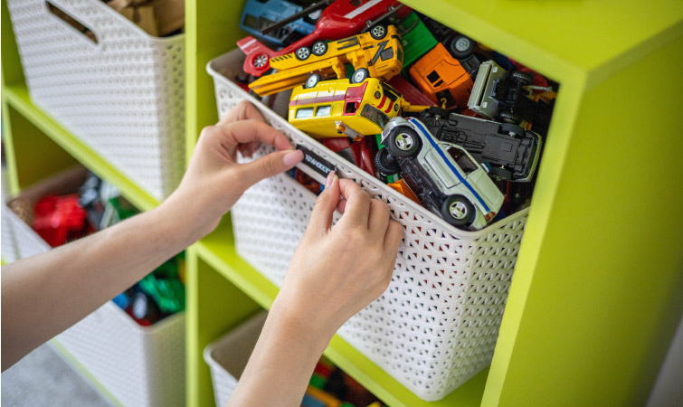 A woman placing labels on toy storage bins