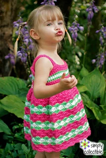 little girl wearing a pink, white, and green crocheted dress