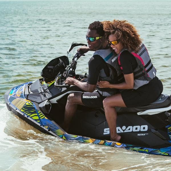 African American couple riding jet ski on water