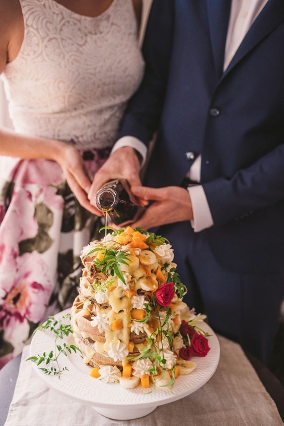 photo of couple pouring syrup on waffle wedding cake
