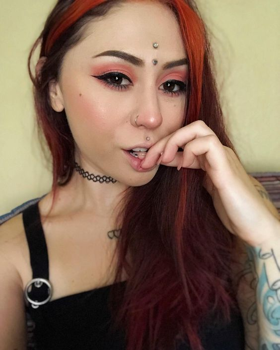 Lady shows off her third eye piercing in a selfie