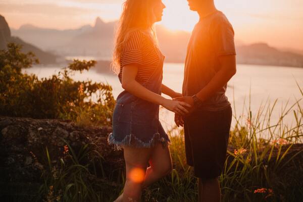 Foto de um casal com o por-do-sol ao fundo