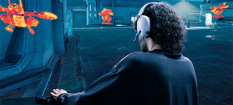 Man wearing INZONE H3 headset in a game scene showing buildings and hidden targets highlighted in orange