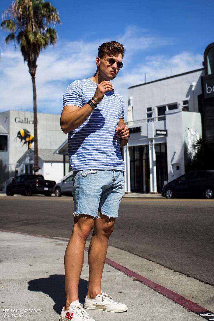 men wearing blue shorts and a striped blue t-shirt and posing on the road