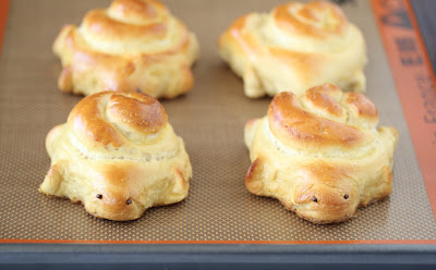 photo of four turtle soft pretzels on a baking sheet