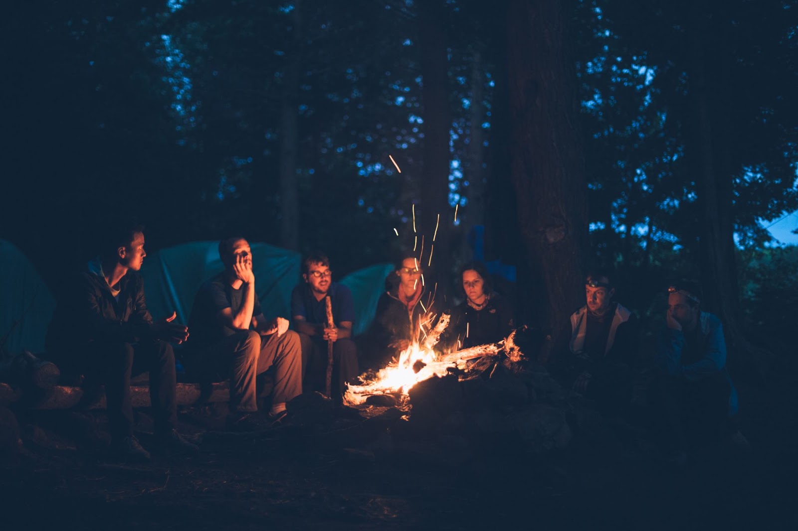 A group of people telling stories around a fire.
