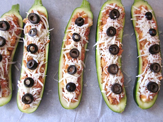 black olives on top of stuffed zucchini ready to bake 