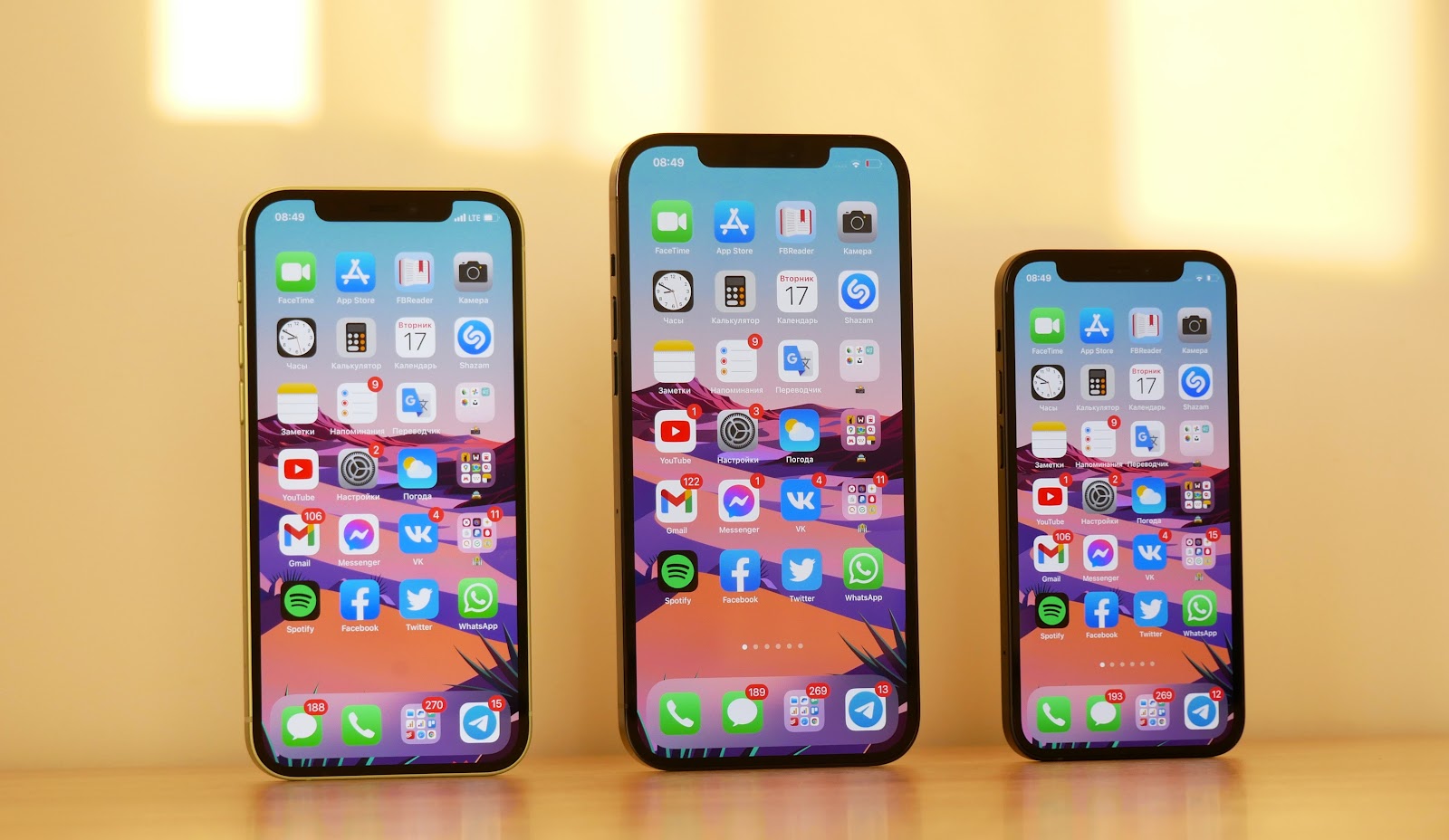 three iPhones standing side by side