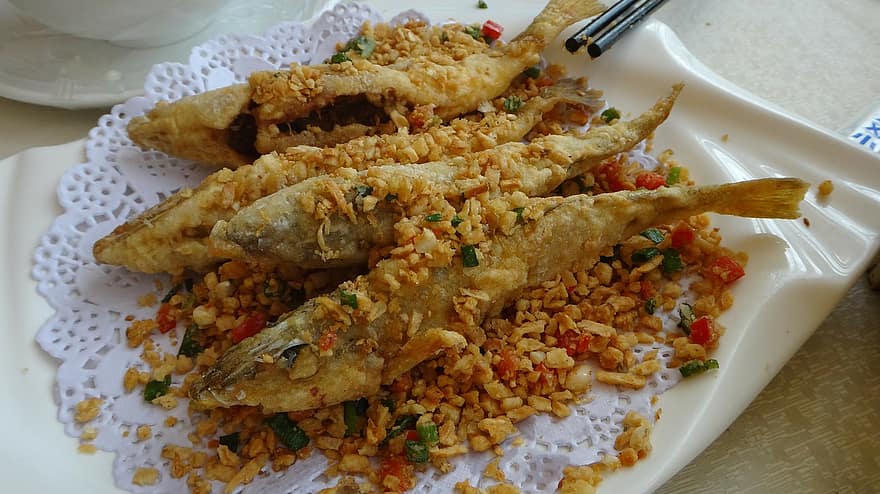 魚を揚げて野菜を散らしたレースペーパーの上に乗せた画像です。