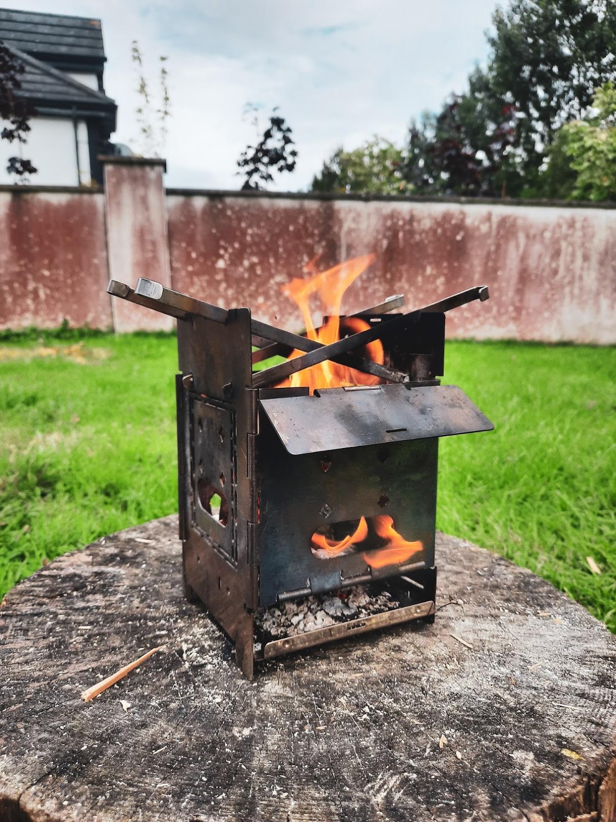 A close up of a fire place sitting in a yard

Description automatically generated