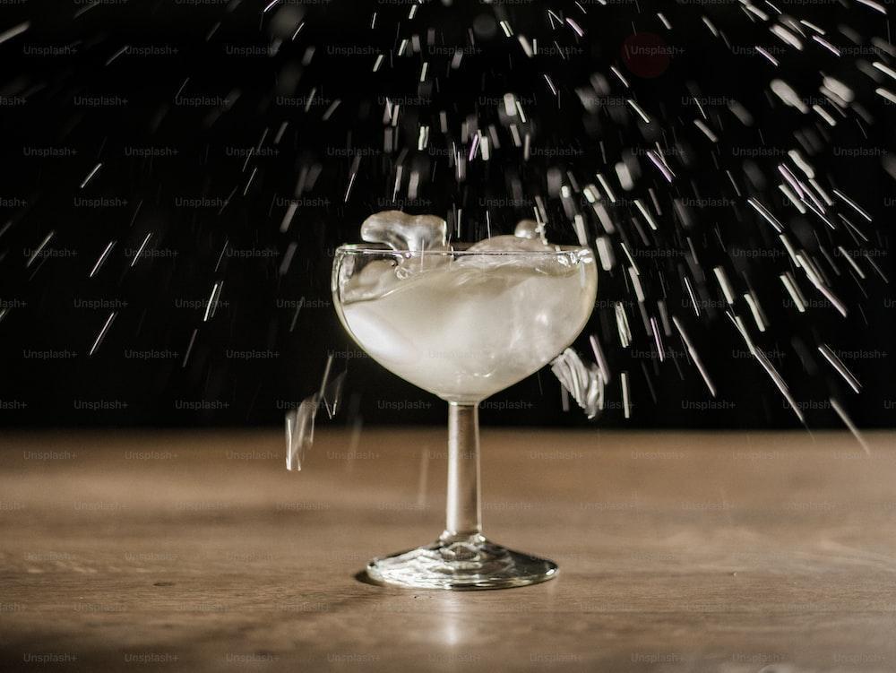 a glass filled with liquid sitting on top of a wooden table