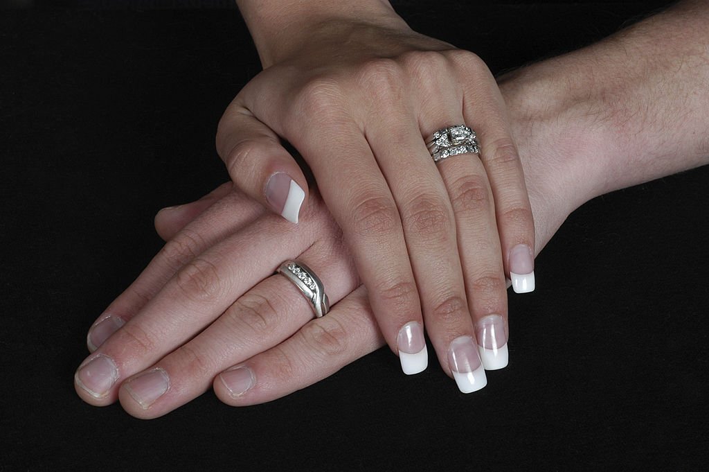 A woman with two silver rings on her ring fingers